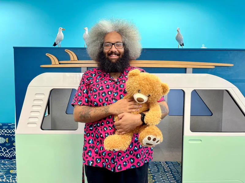 Ryan holding a teddy bear in the library