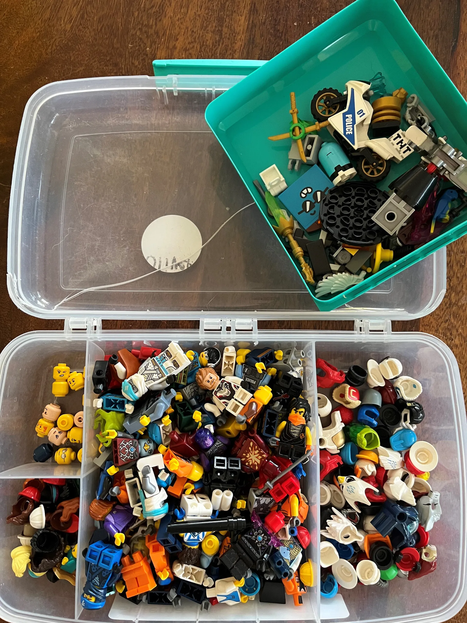 lego characters stored and sorted in an old broken lunchbox