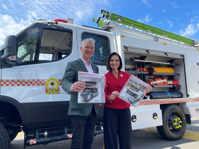 Mayor’s Natoli and Wilkie stand in front of an emergency response vehicle holding Council’s Get Ready packs.