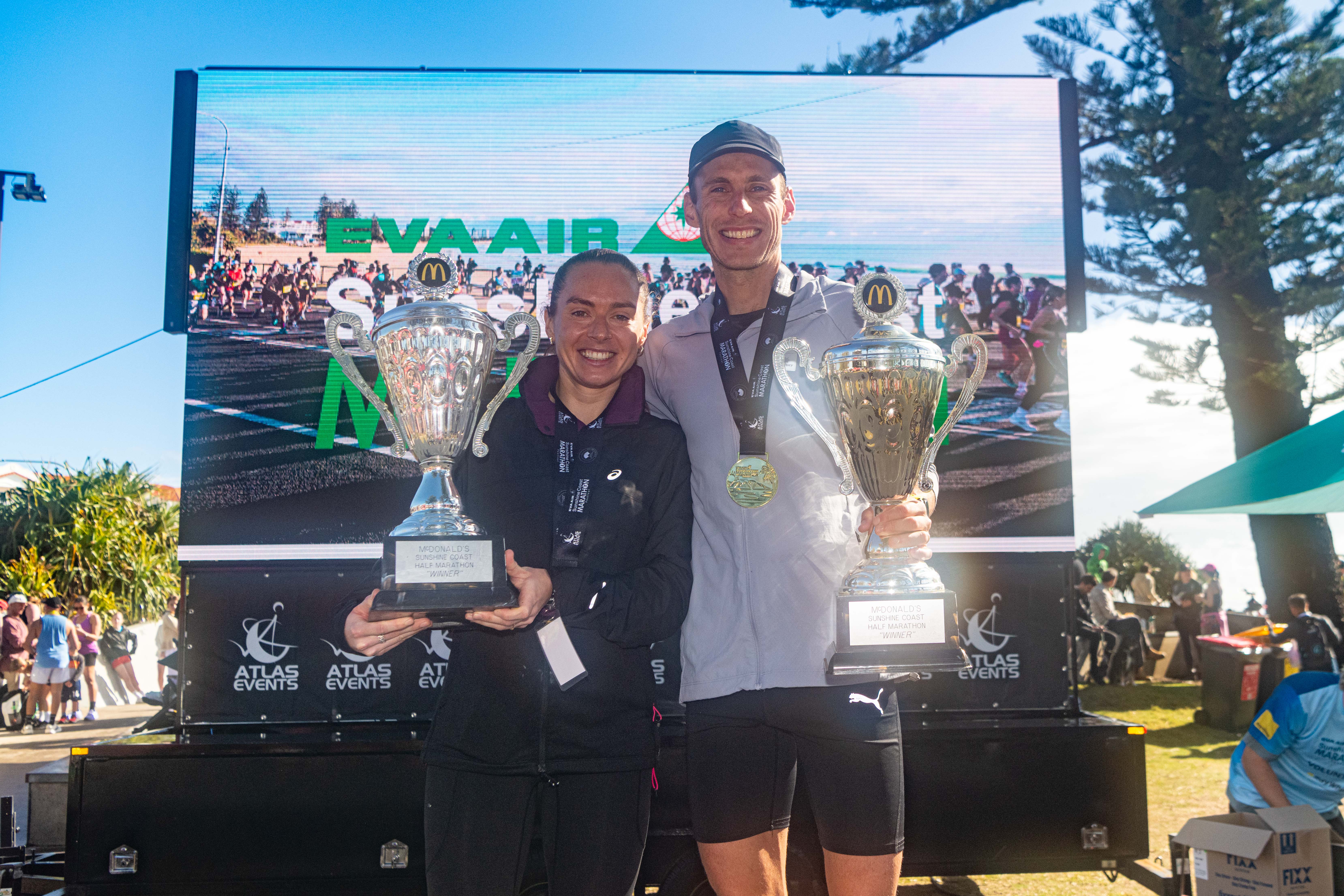 The McDonald’s Half Marathon saw two of Australia’s leading distance athletes add their names to the Sunshine Coast honour roll, with Izzi Batt-Doyle two-time Olympians Ryan Gregson and taking out the men’s and women’s titles. Holding their trophies.