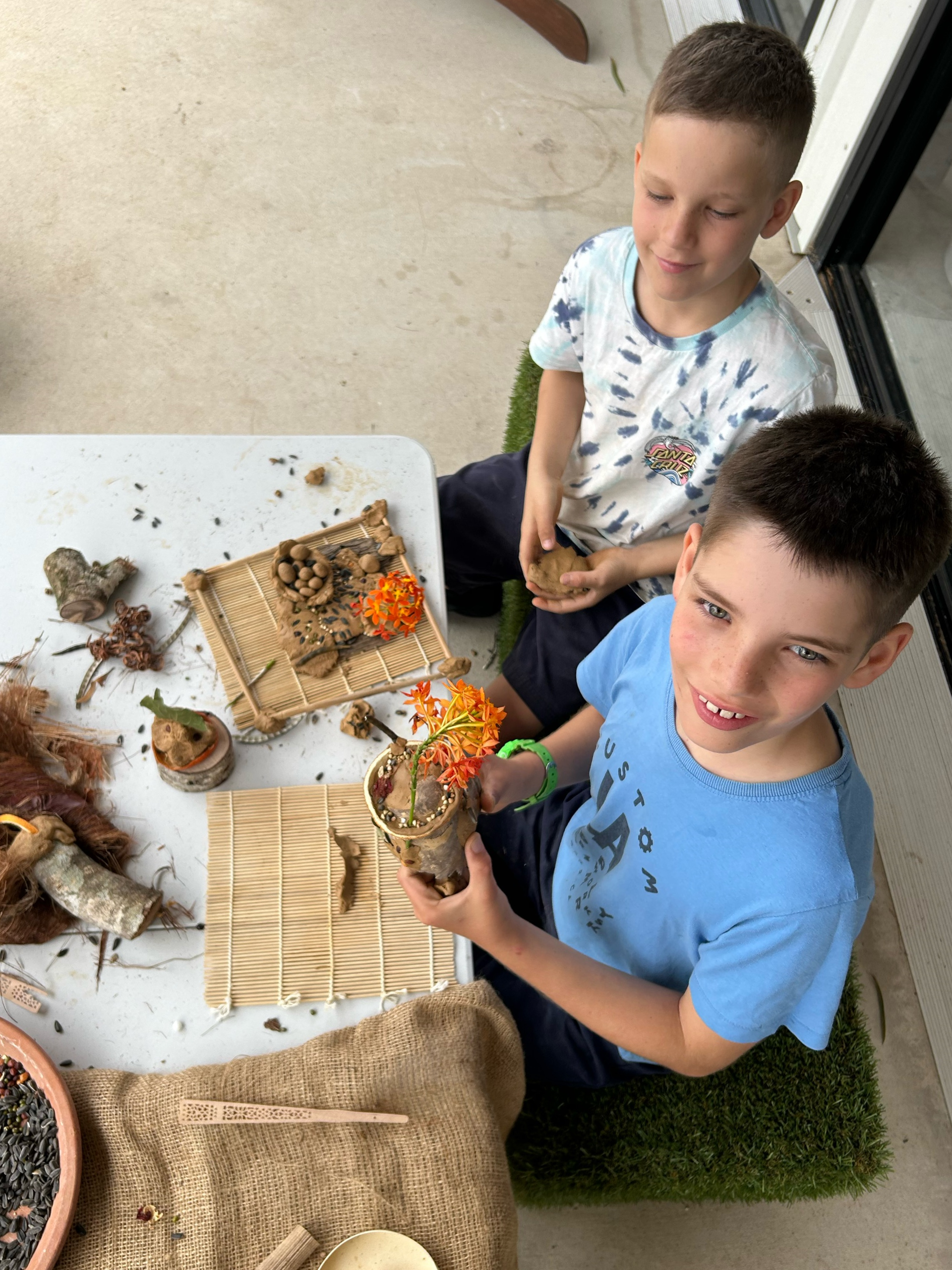 two boys making a seed pod