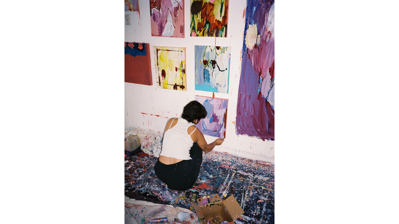 Artist in her studio hanging works