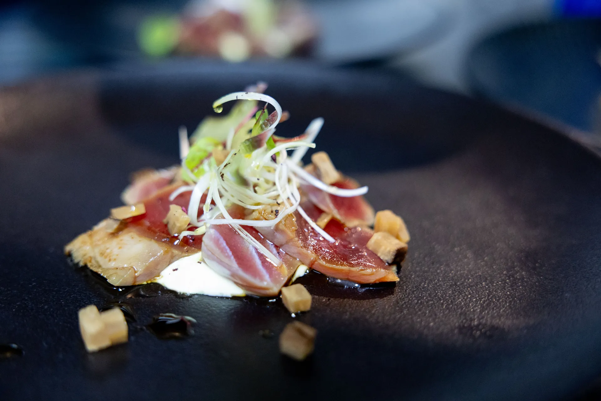 Delicious tuna delicately set on a dark plate.