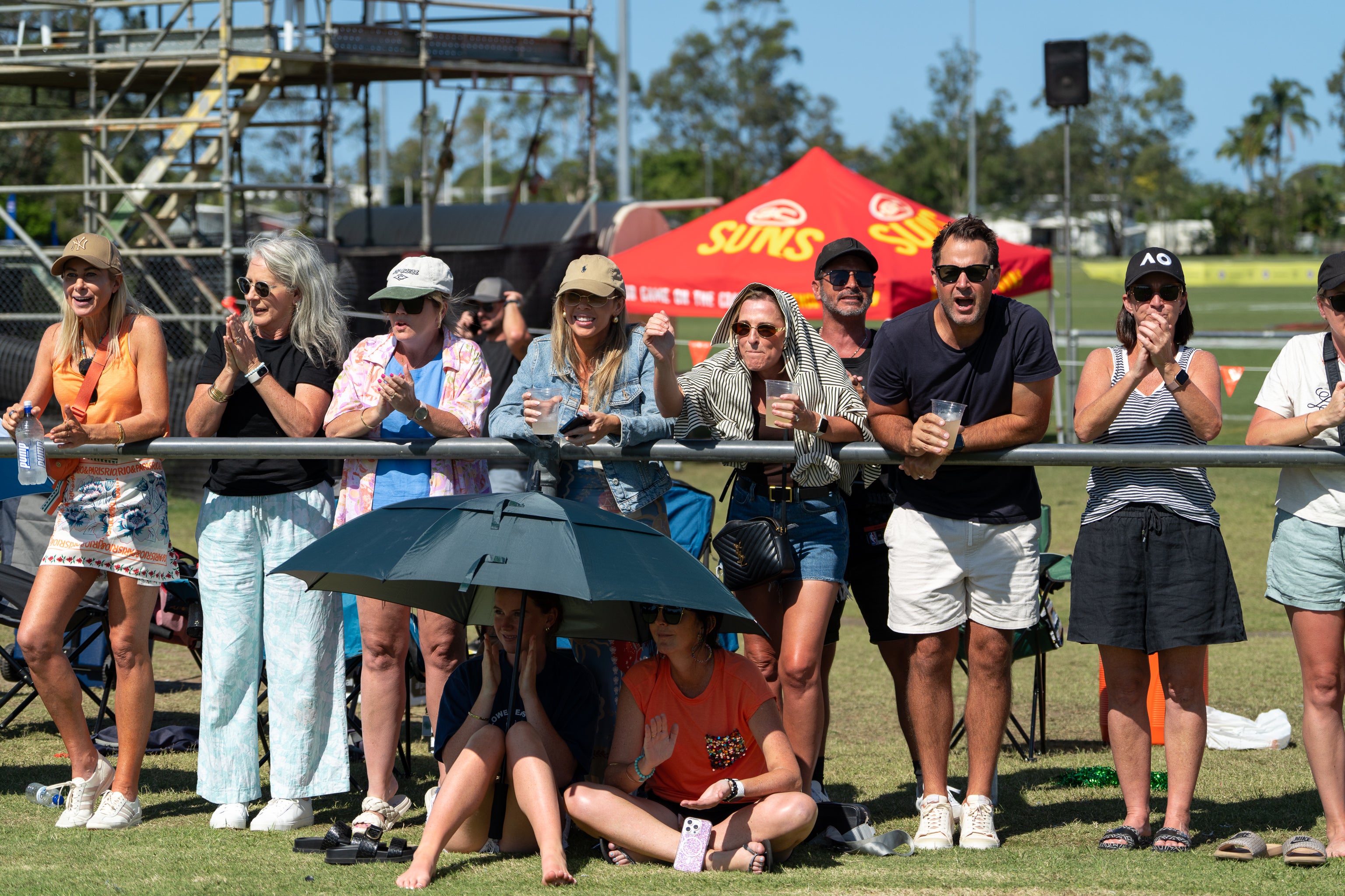 Crowd shot: a line of people - families and friends looking towards the field of play.