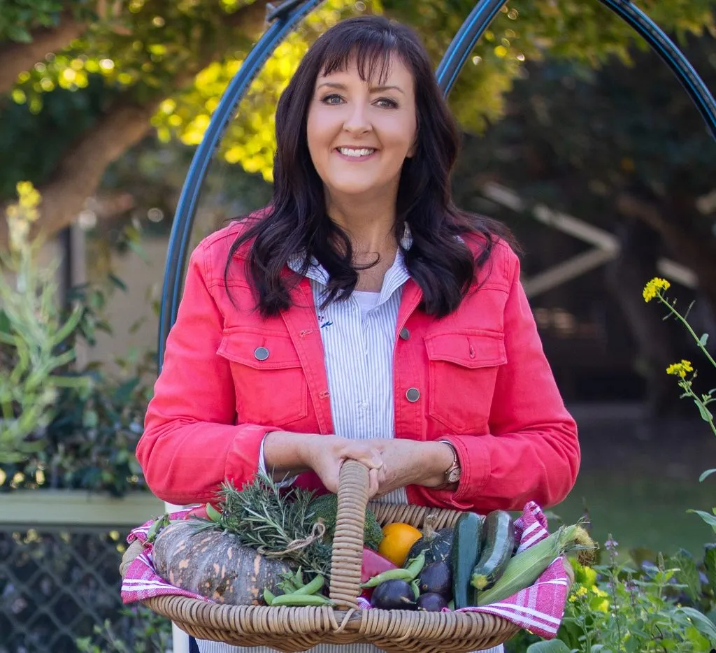 Anne Gibson carrying a basket of veg