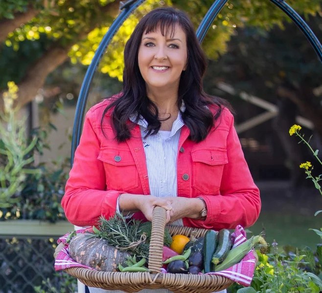 Anne Gibson carrying a basket of veg