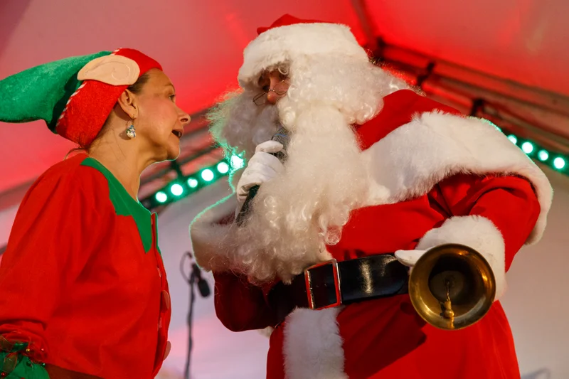 Santa and an elf singing carols