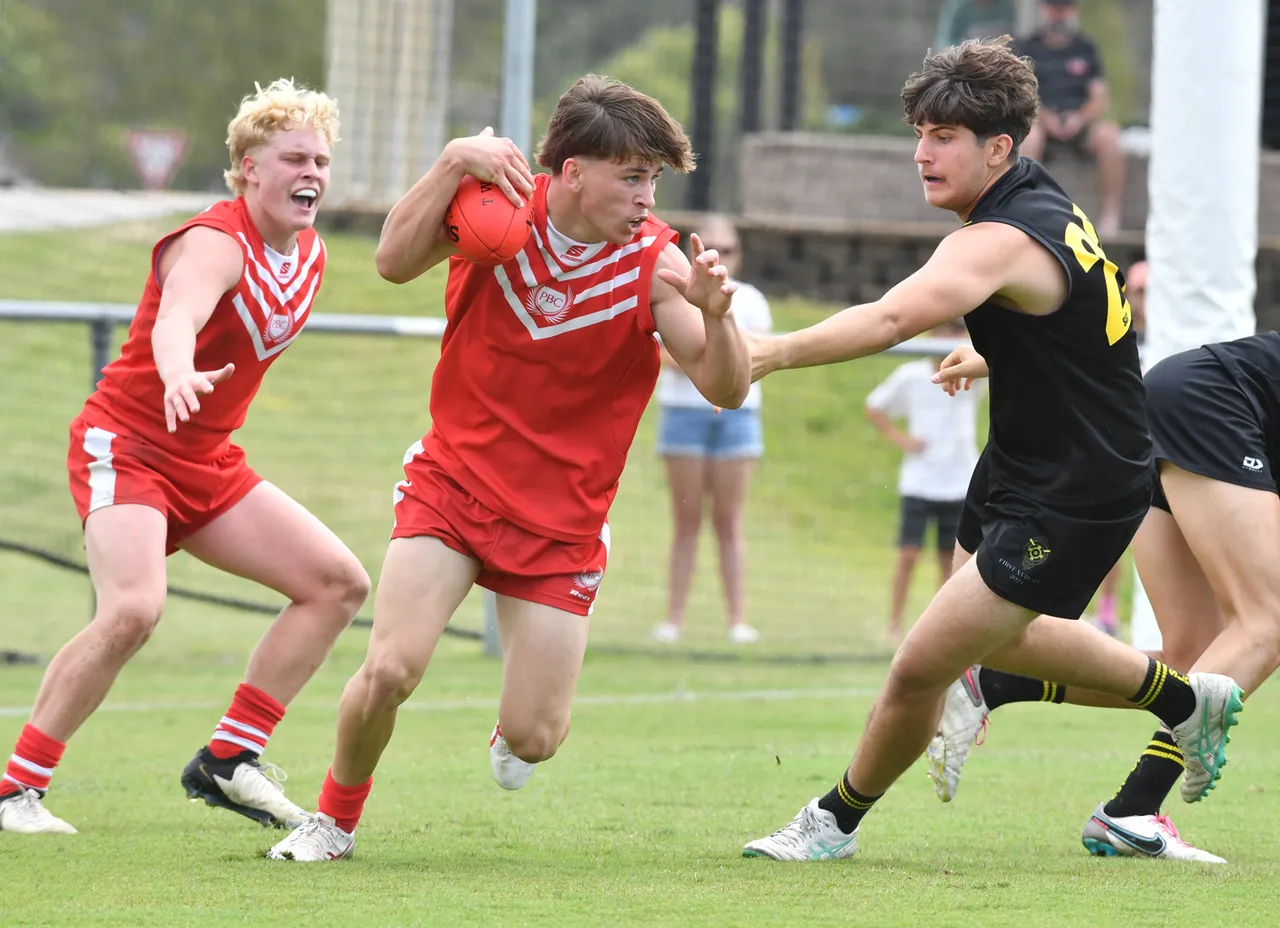 Three AFL players on field and in motion.