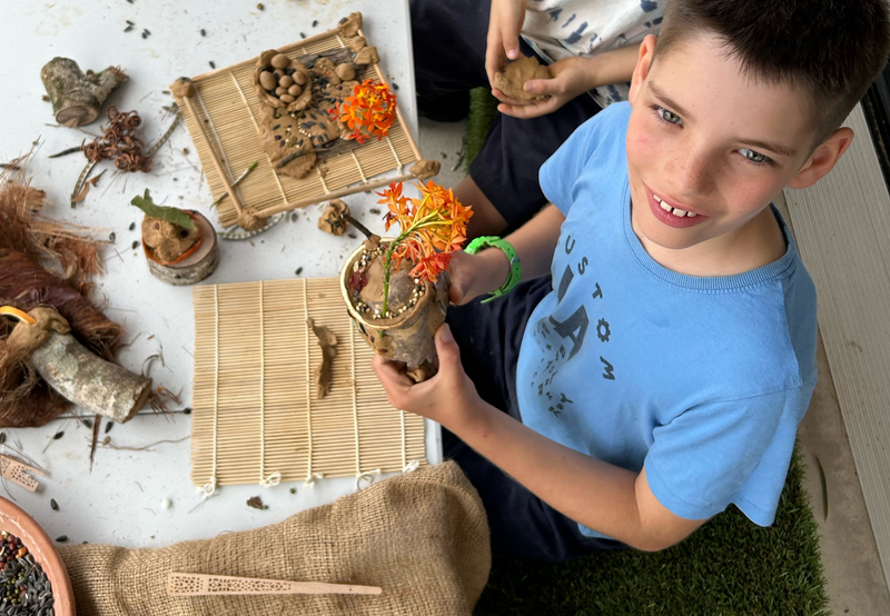 Mason Quarrell try out the "seed bomb" activity ahead of BiospHERO Day, creating art for the garden that will flourish into new plants.