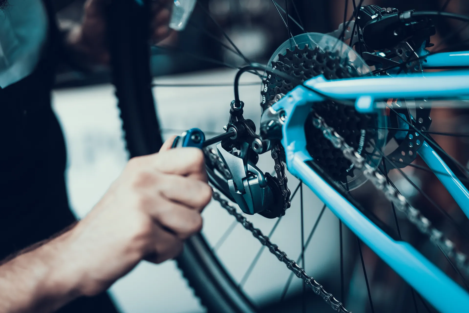 mans hand tightening a screw on a bike