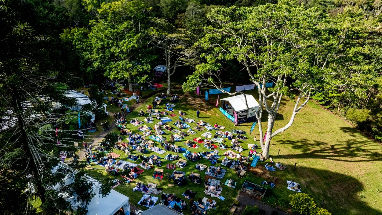A drone shot - looking down on the Spicers Tamarind lawns full of people enjoy a picnic style event
