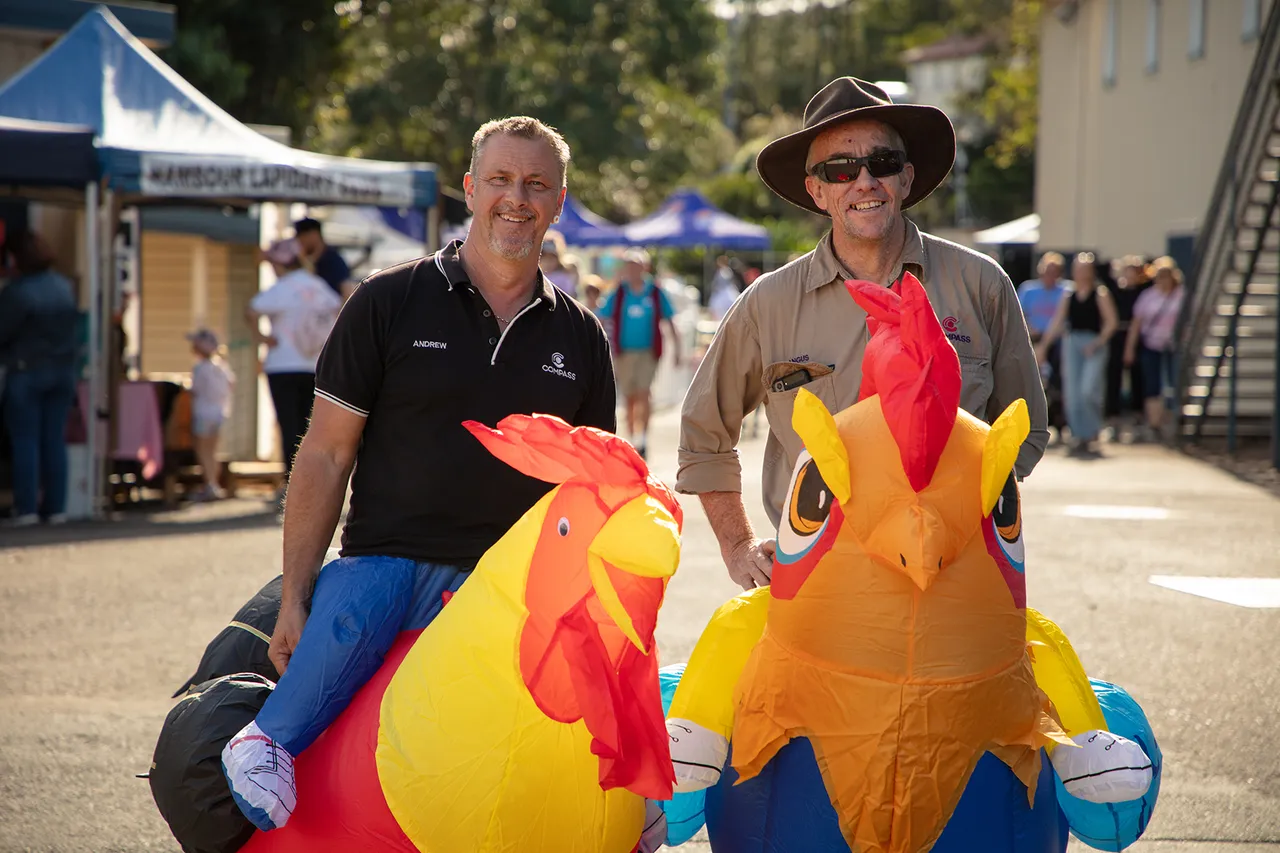 Two people wearing chicken / rooster costumes