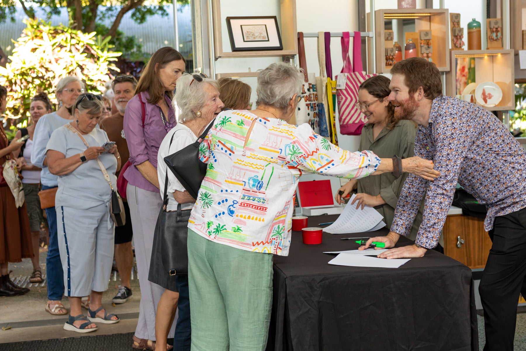 Crowds of people waiting to enter the gallery at the Wildflowering by Design exhibition launch