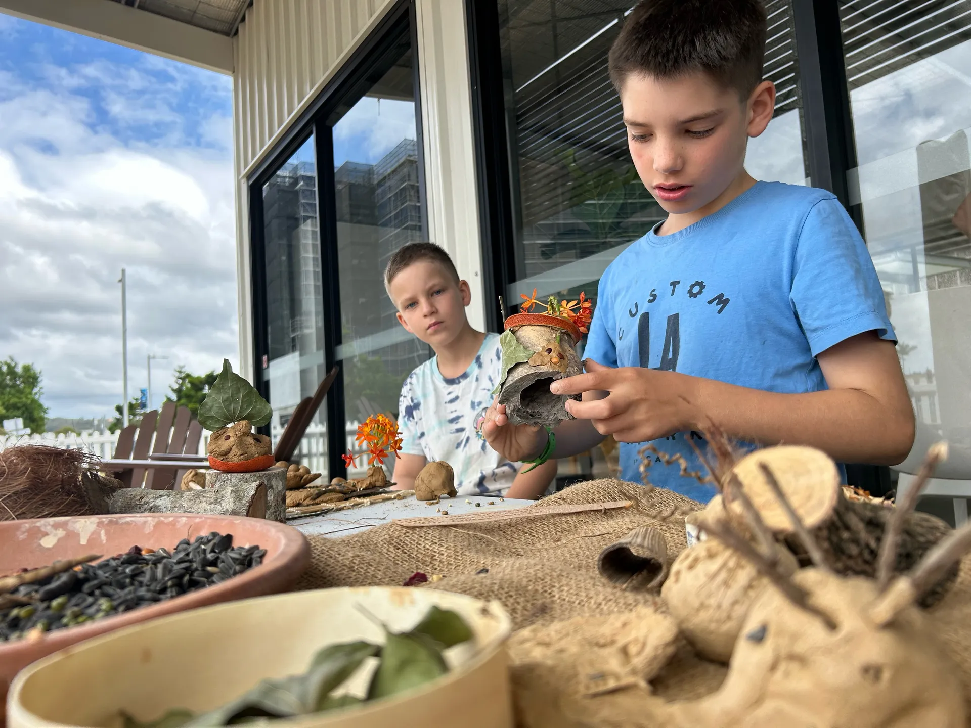Hunter Quarrell and Mason Quarrell try out the "seed bomb" activity ahead of BiospHERO Day, creating art for the garden that will flourish into new plants.