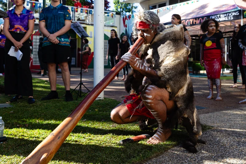 First Nations man playing the didgeridoo.