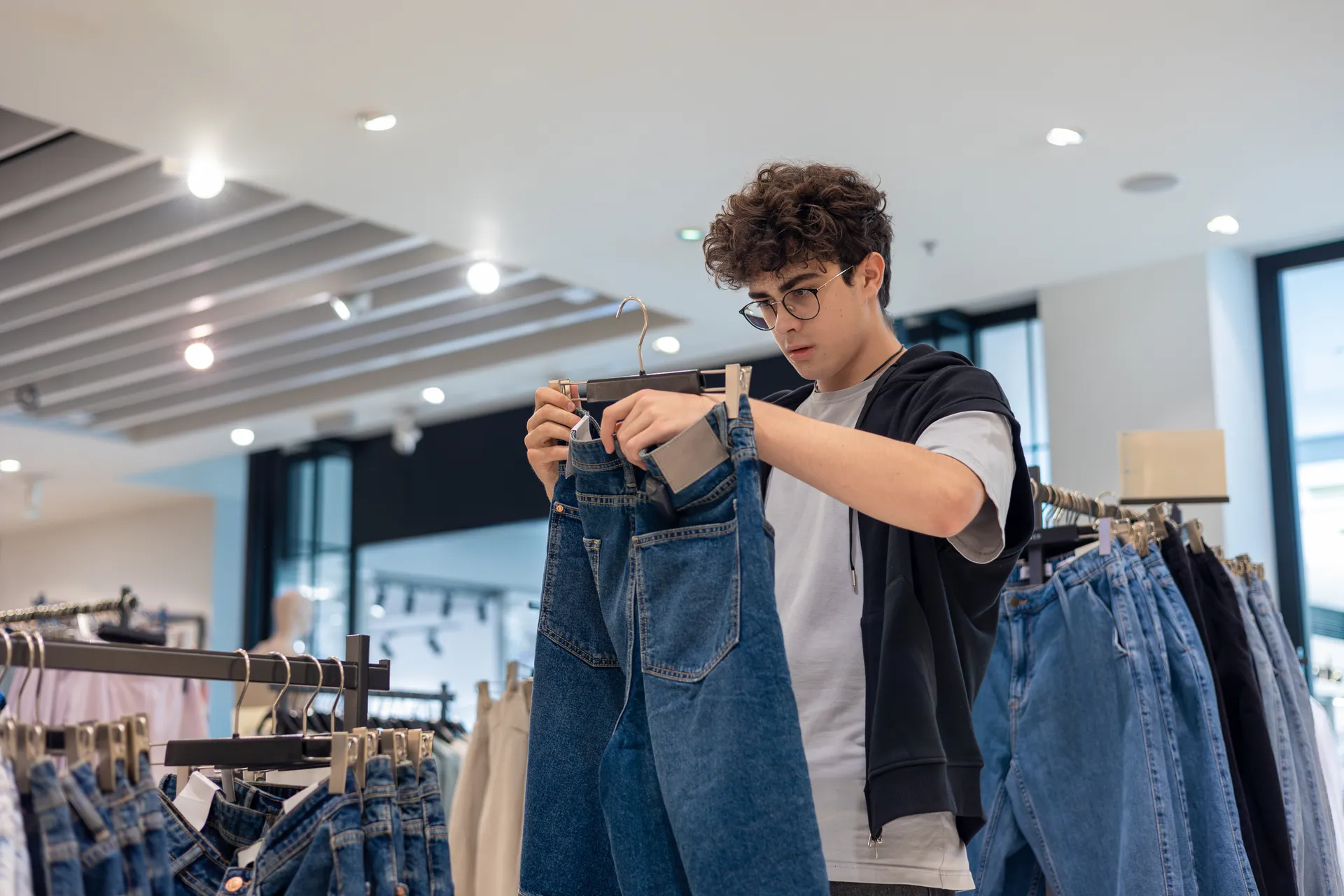 man holding jeans and reading the label