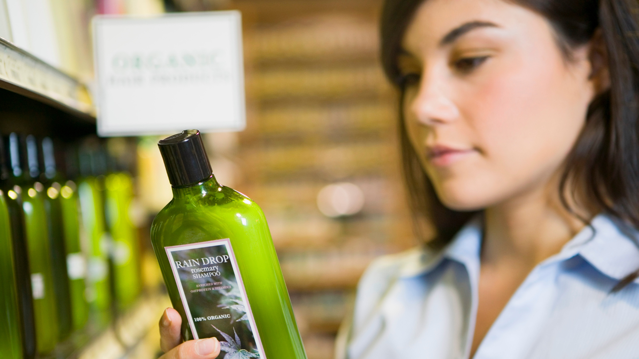 lady reading a shampoo bottle label