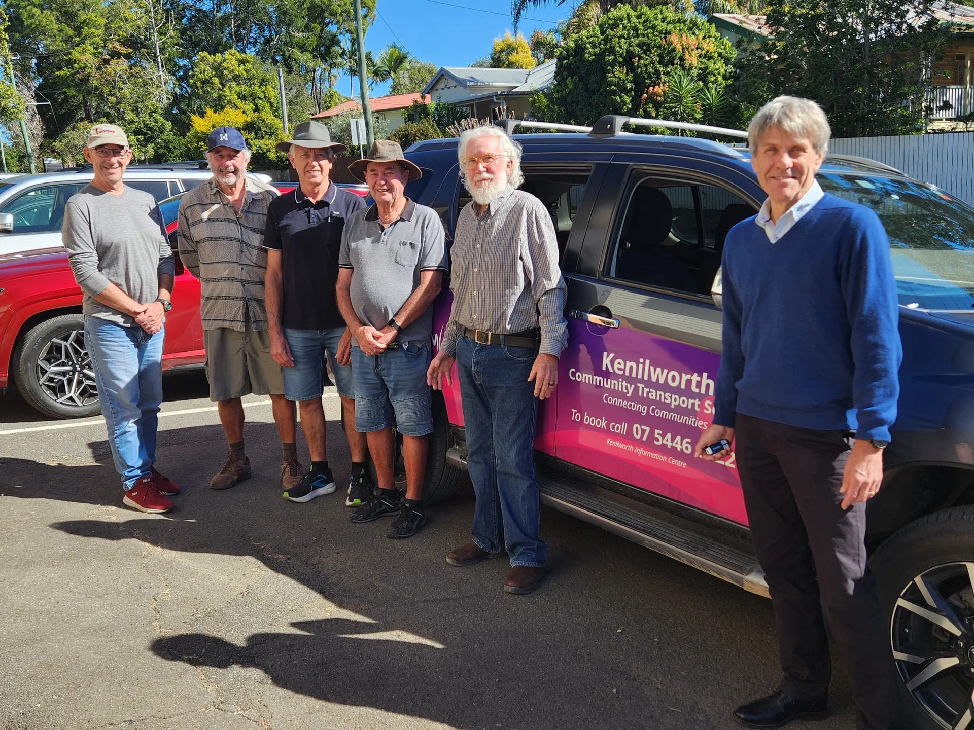 Group of men involved with the service, including Sunshine Coast Council Division 10 Councillor David Law, stand with a community transport vehicle.