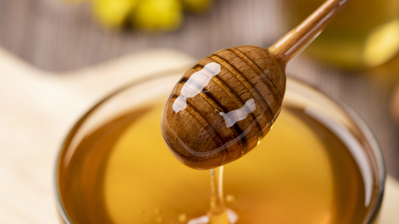Delicious Golden honey dripping from a honey stick.