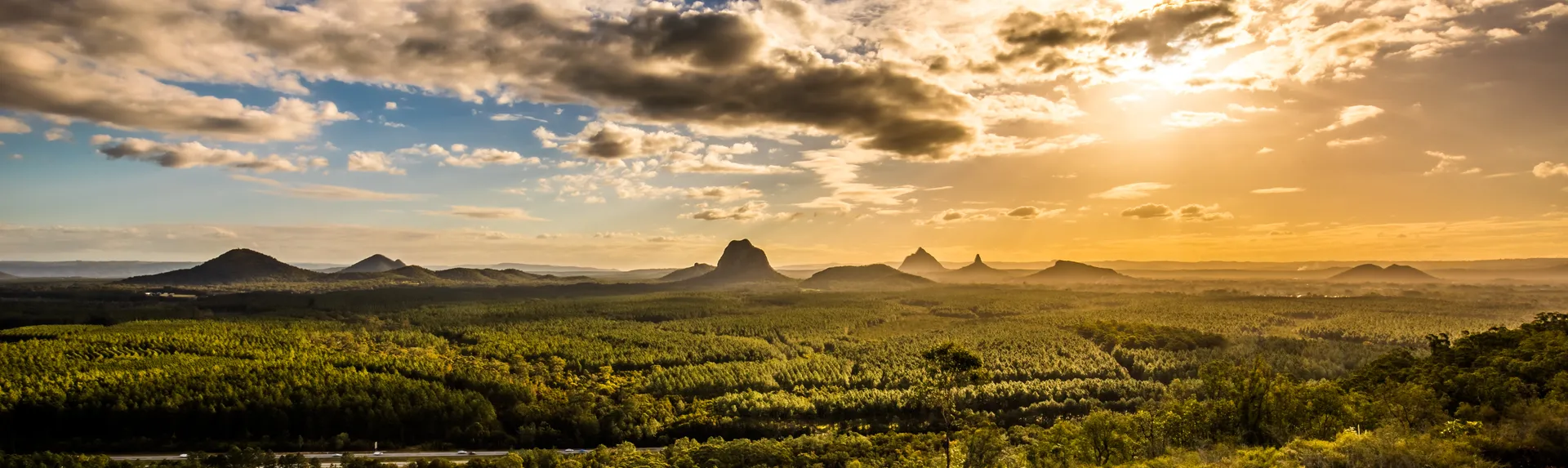 Panoramic view of Glass House Mountains at sunset visible from Wild Horse Mountain Lookout
