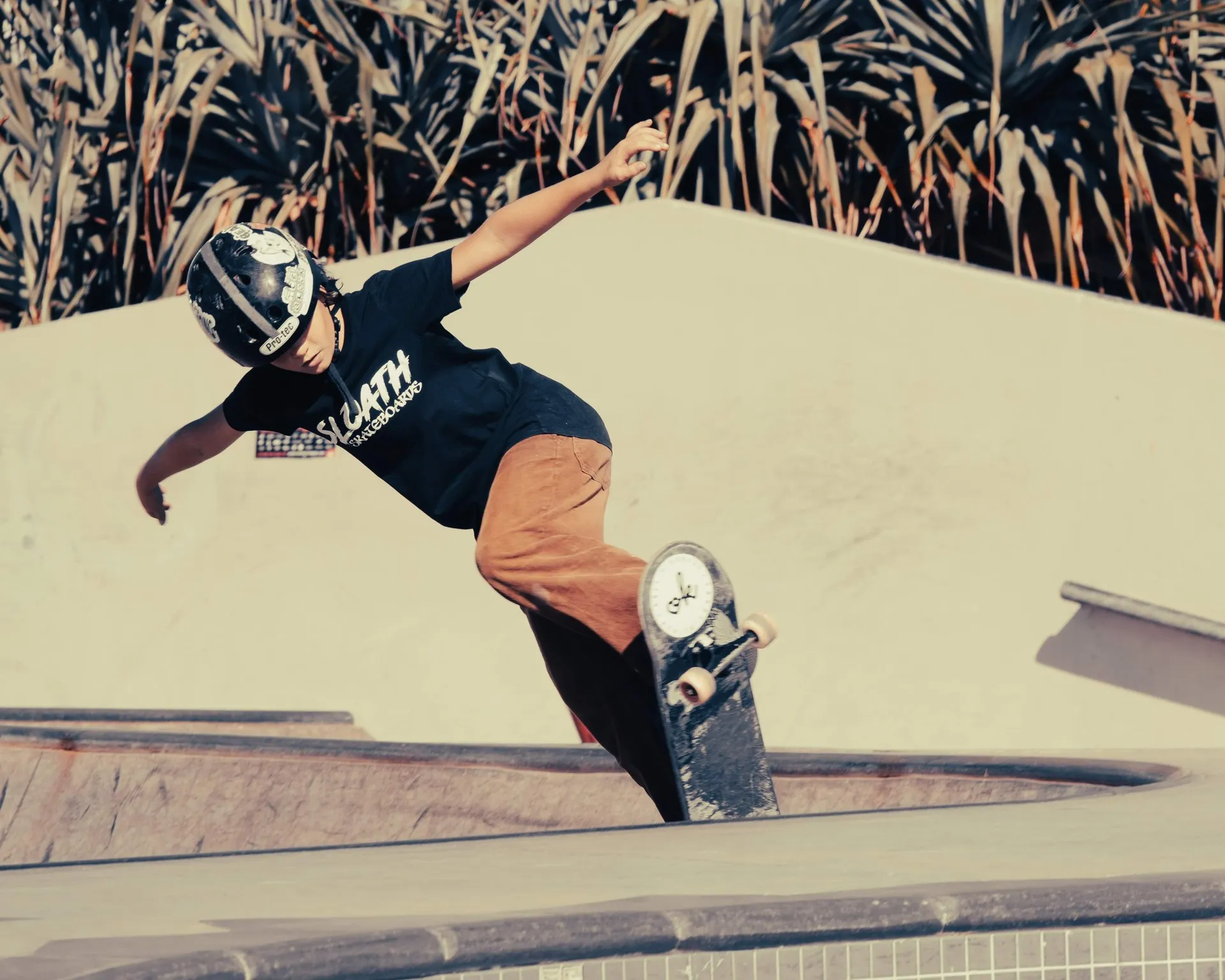 A skateboarder on the edge of a stakebowl
