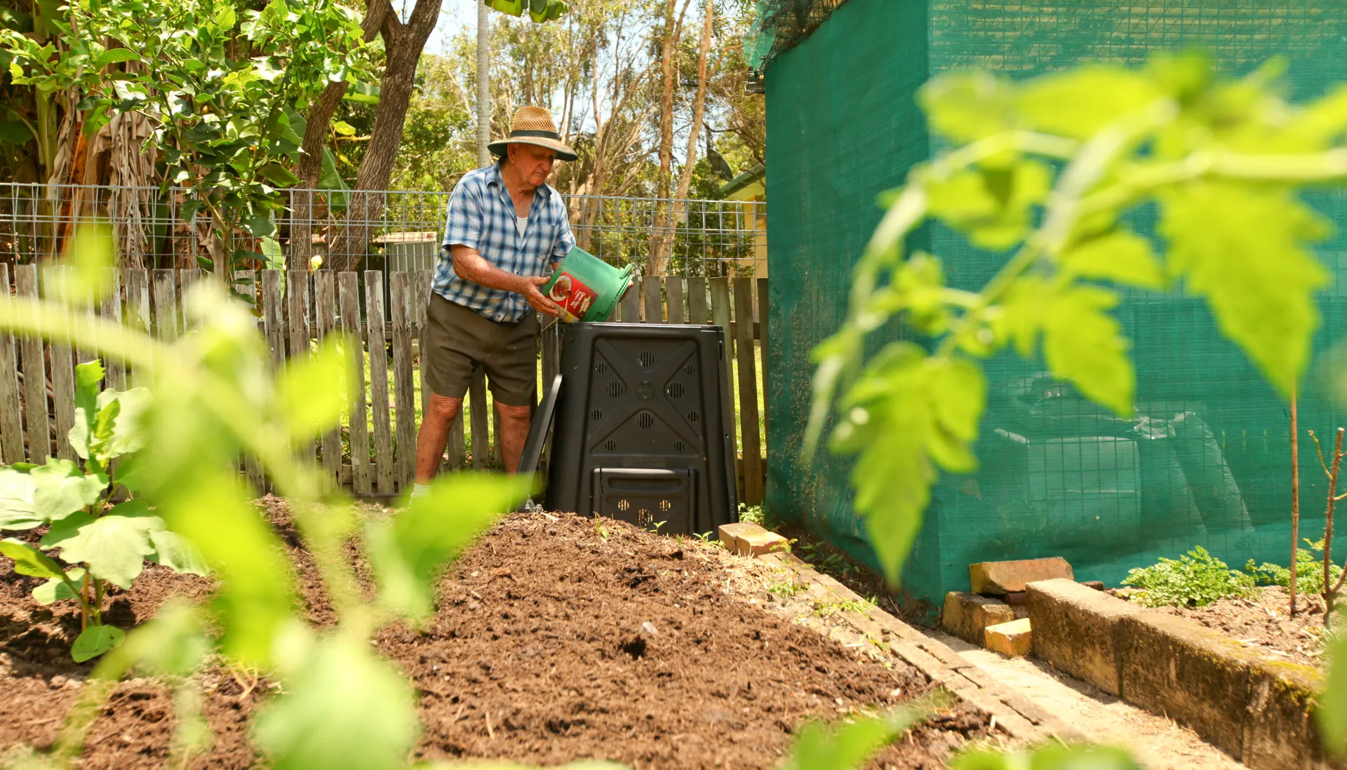 A man adding to his compost bin