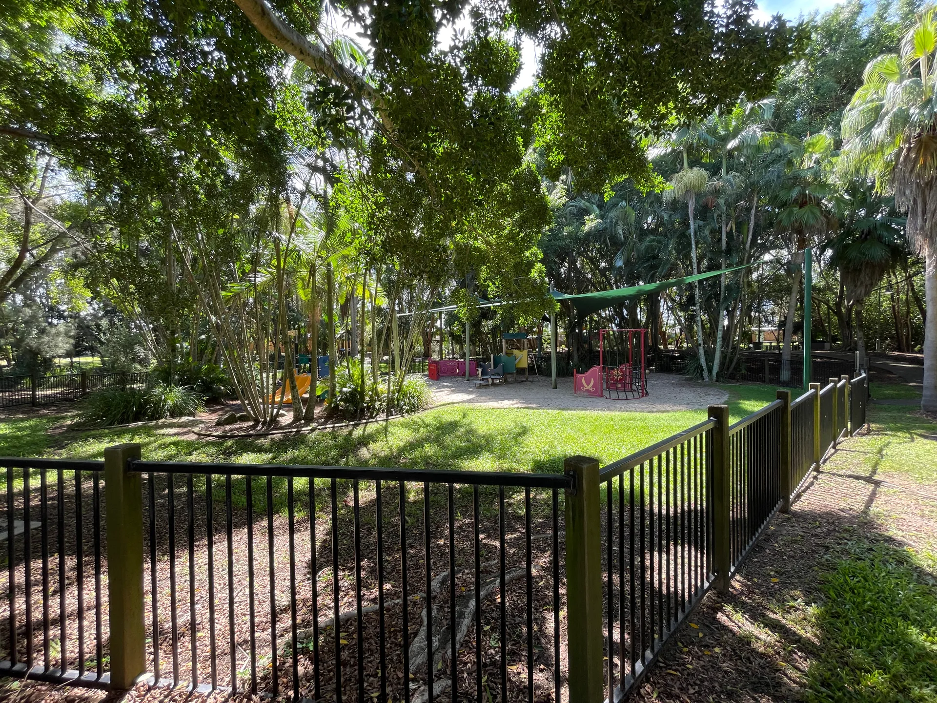 Fenced Playground with swings and play equipment