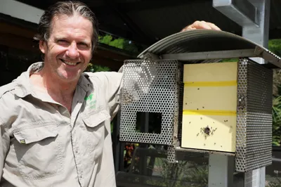 Ian Driver holding up a bee hive