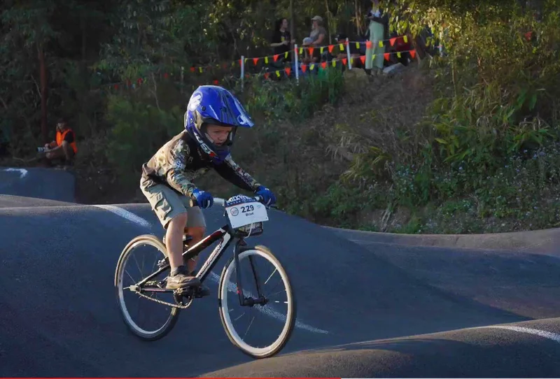 Young child riding a bicycle on a pump track