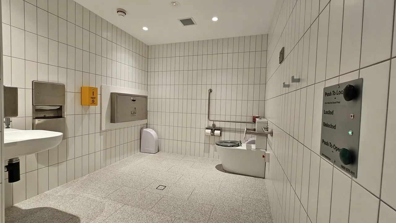 Altitude Nine amenities - toilet, sink, baby change station with signage and buttons on the wall for exit