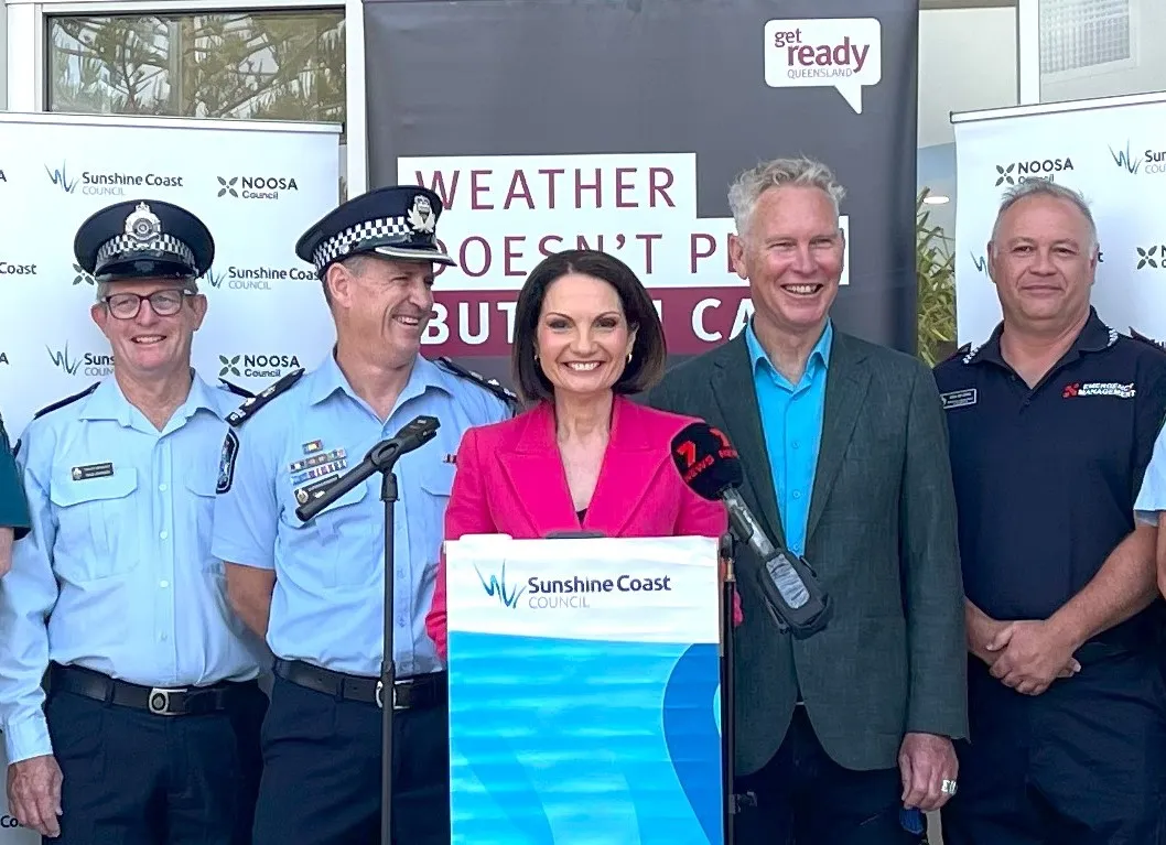 Mayor Natoli and Frank Wilkie are smiling as they stand behind a podium for the Get Ready Week launch. They are flanked by smiling emergency service personnel in uniform.