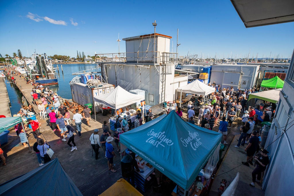 Image of people milling around the fisheries area at The Spit, Mooloolaba