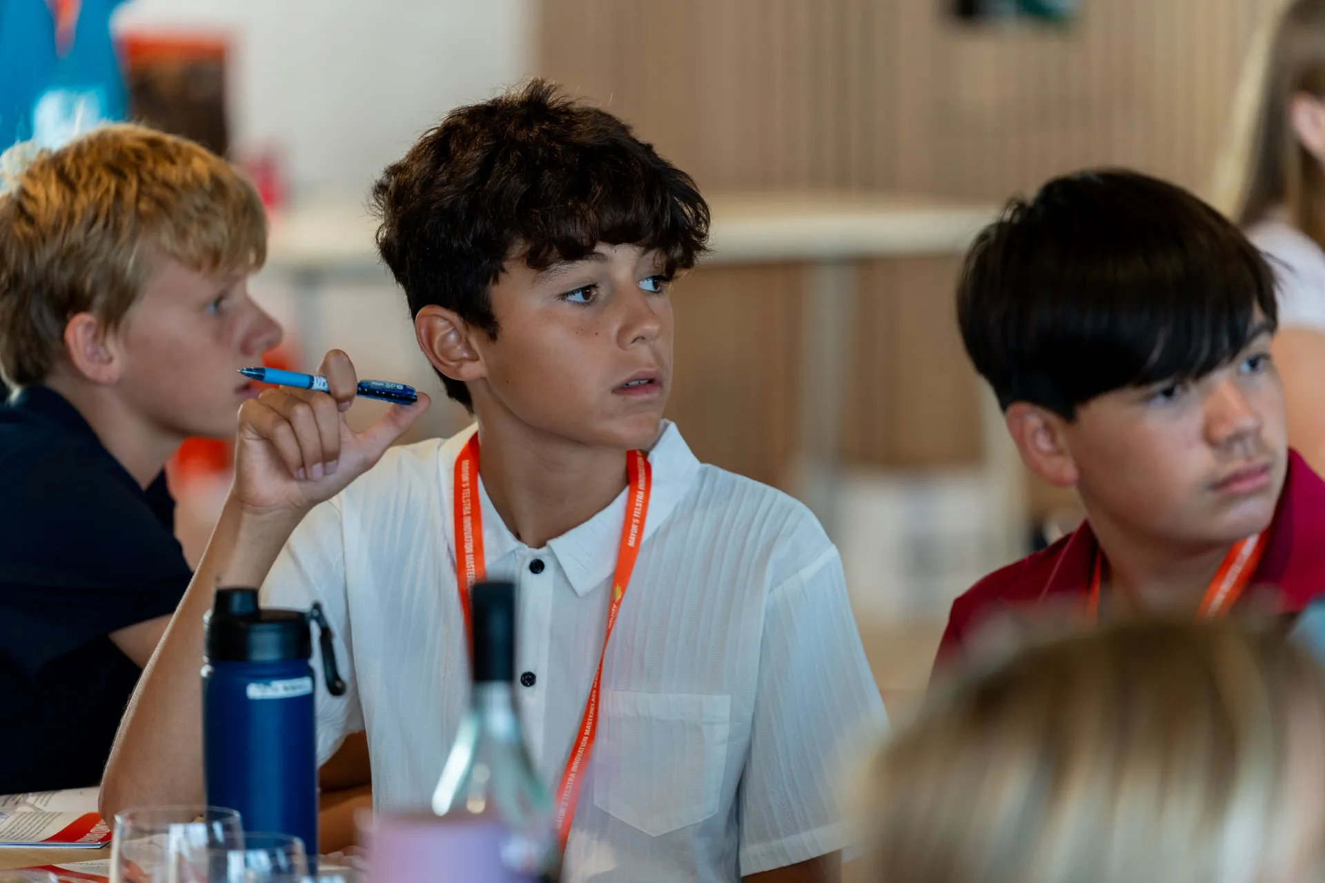 Three seated students, looking towards the facilitator