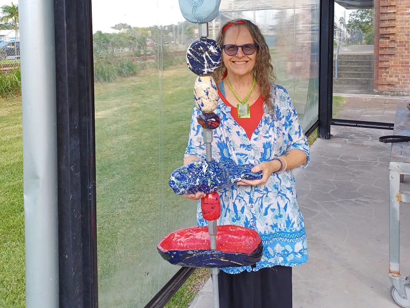 Aunty Jude Hammond (Gunggari/Kamilaroi) with one of the finished brightly coloured songline sculptures made for the Contemporary Songlines exhibition at Caloundra Regional Gallery