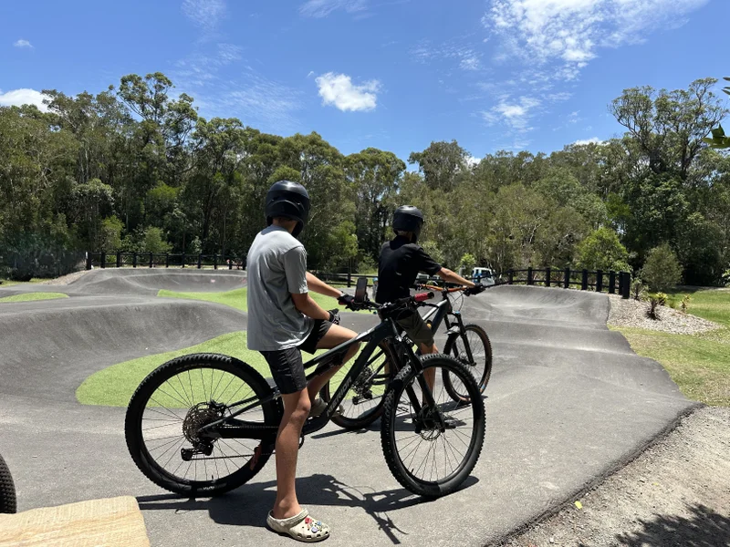 Two boys on mountain bikes at pump track