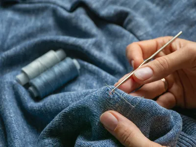 repairing a hole in clothes by hand
