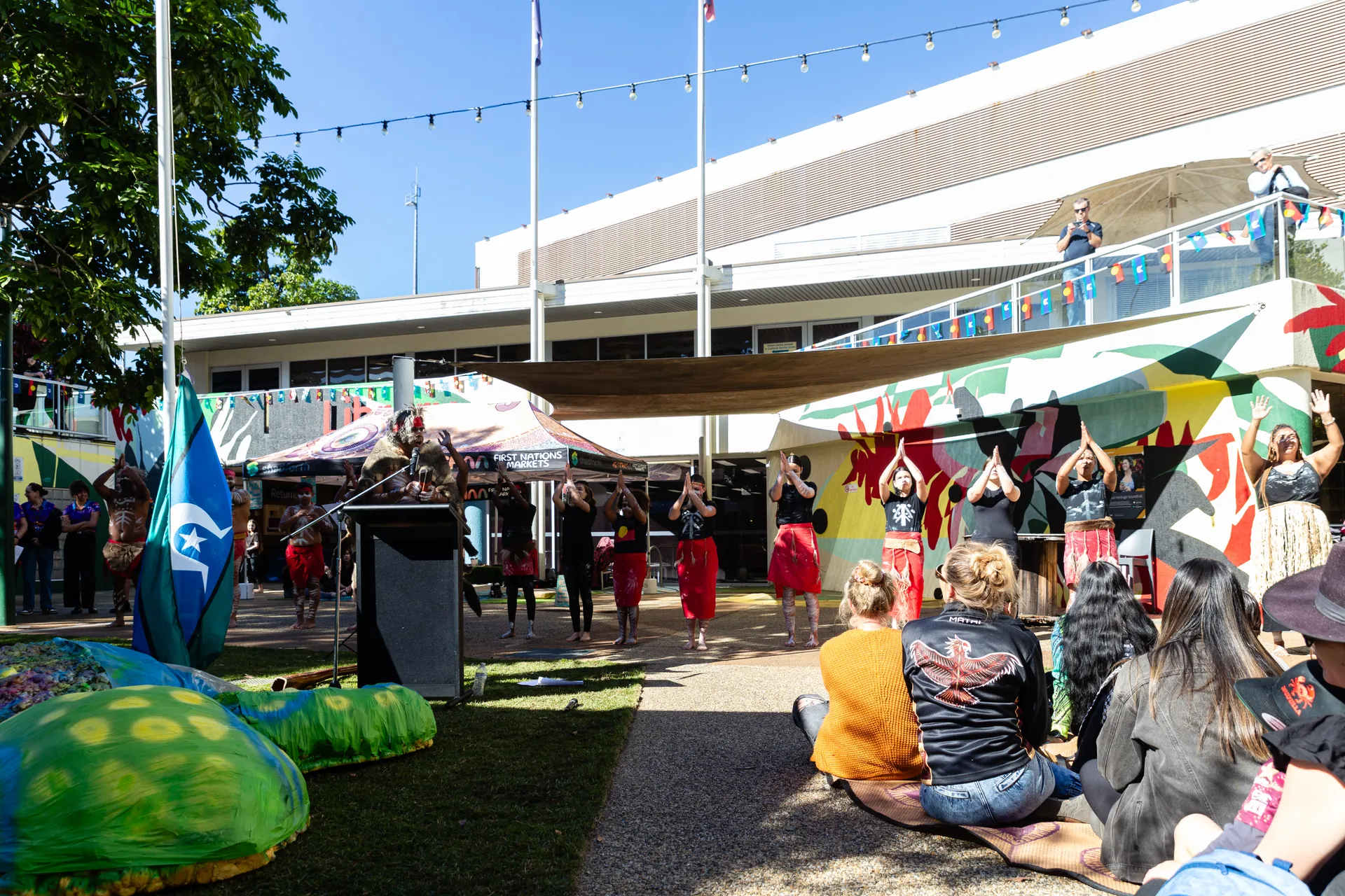 First Nations performers at the Flag Raising ceremony, watched by the crowd.