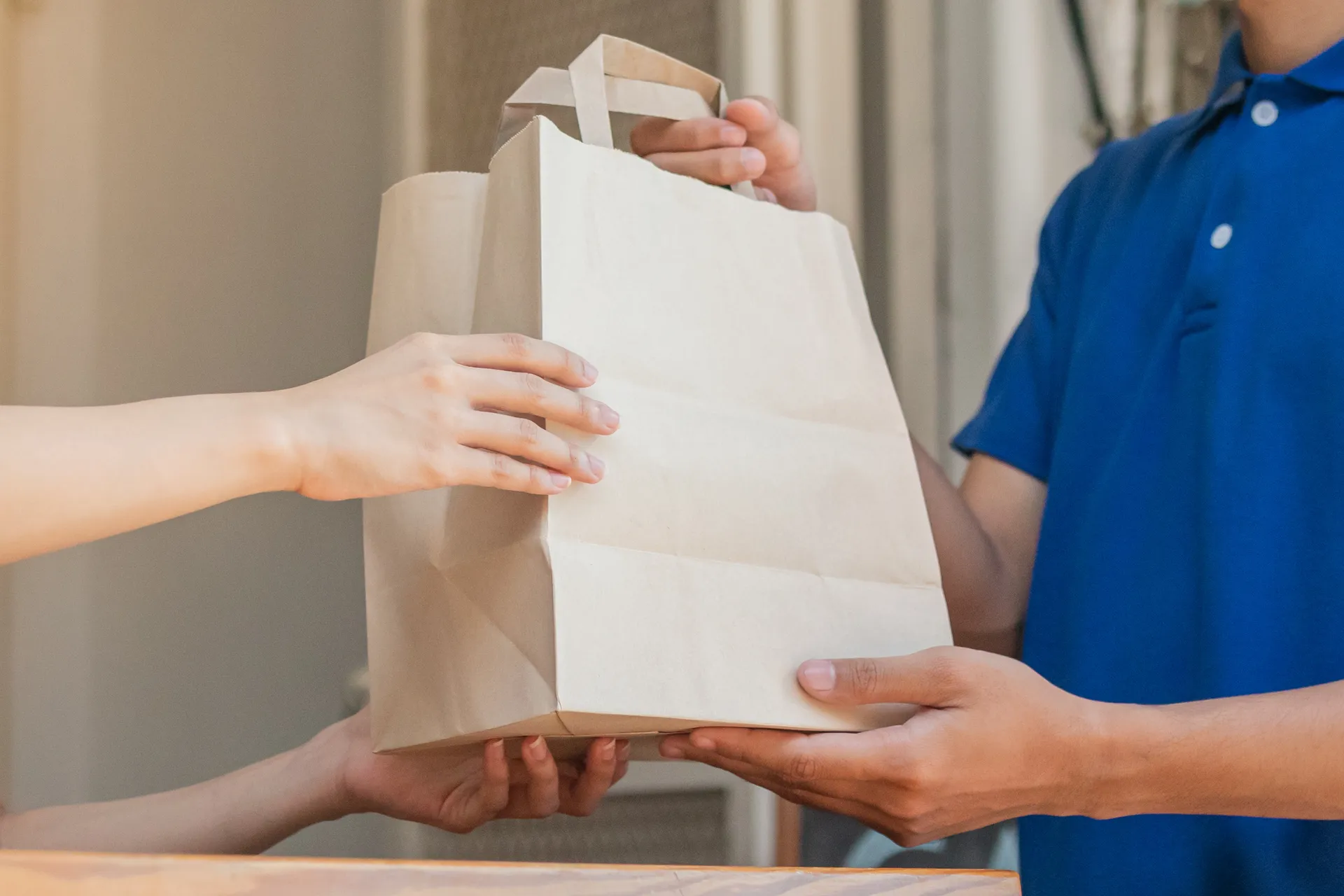 someone passing a bag to another person at a front door