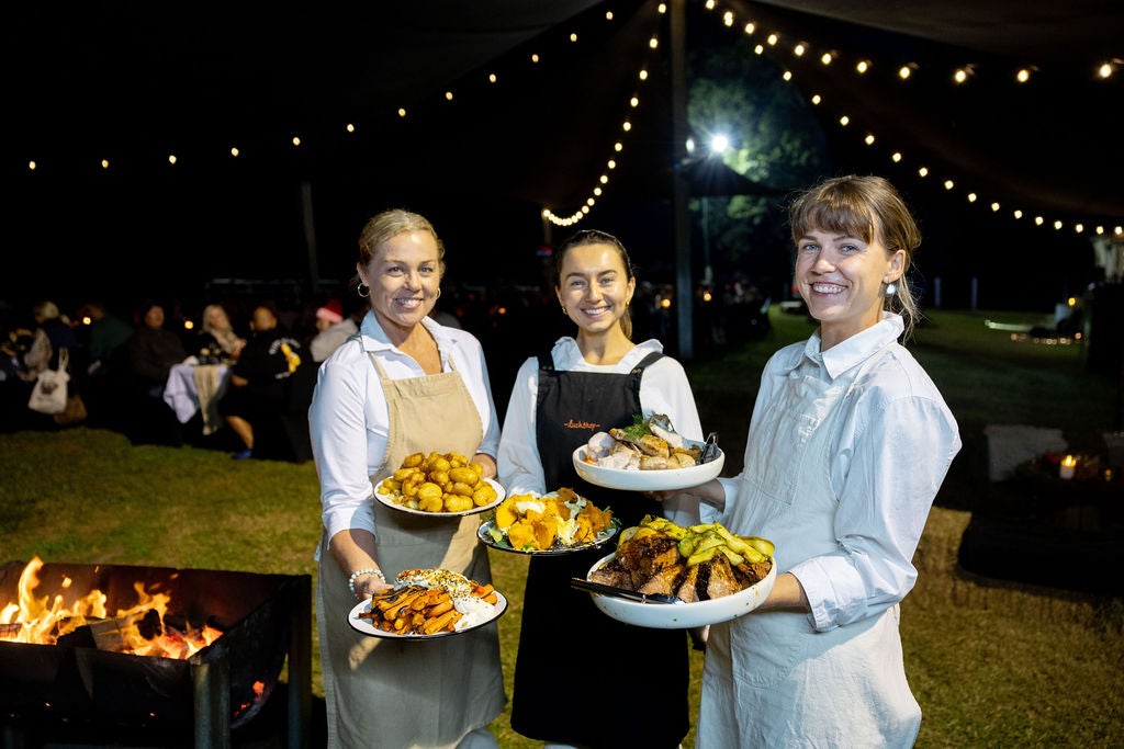 Three people holding plates to serve up at the Kenilworth Ember & Harvest Weekend event Wildfire & Wine
