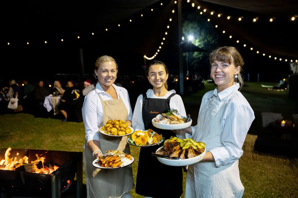 Three people holding plates to serve up at the Kenilworth Ember & Harvest Weekend event Wildfire & Wine