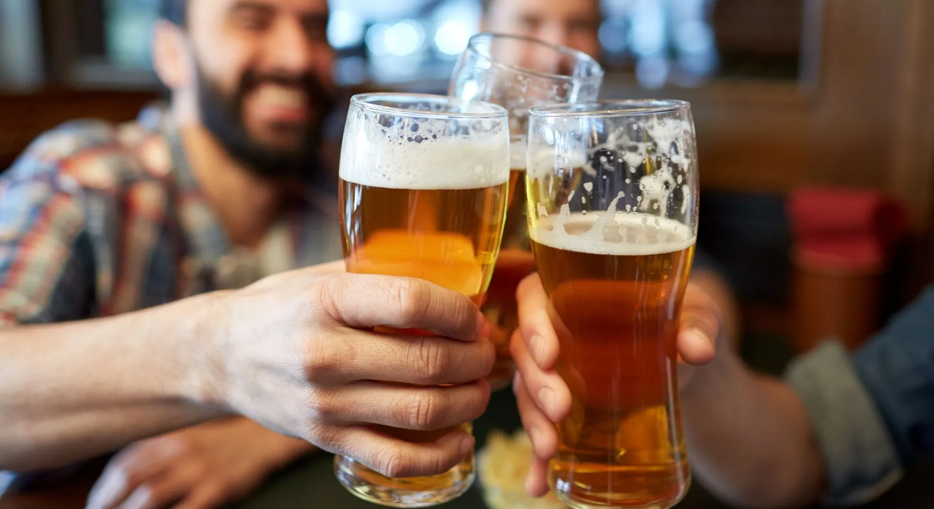 People clinking beer glasses together
