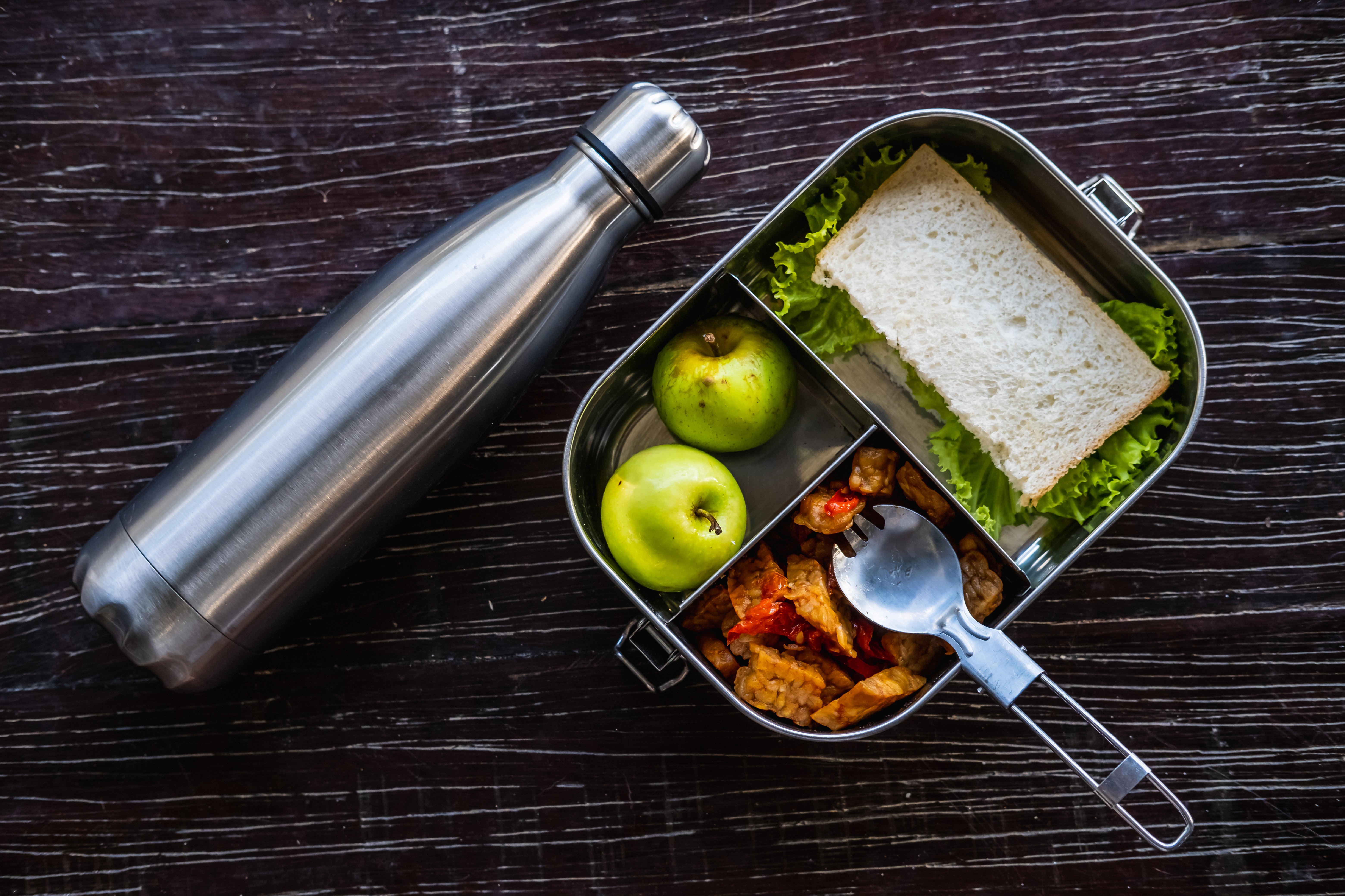 Stainless steel food container or lunch box with healthy vegetarian meal and reusable thermo bottle on wooden background_Eco-friendly kitchen products_Zero waste sustainable plastic free lifestyle