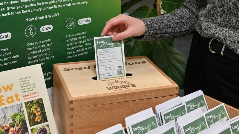 someone posting seeds into a seed library box