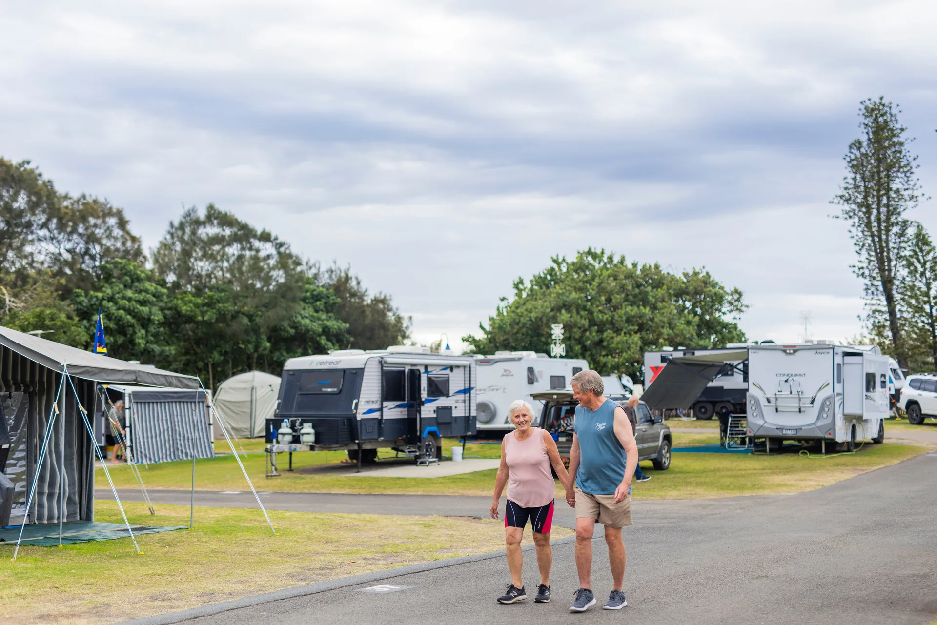 Couple walking through caravan park past campa nd caravan sites