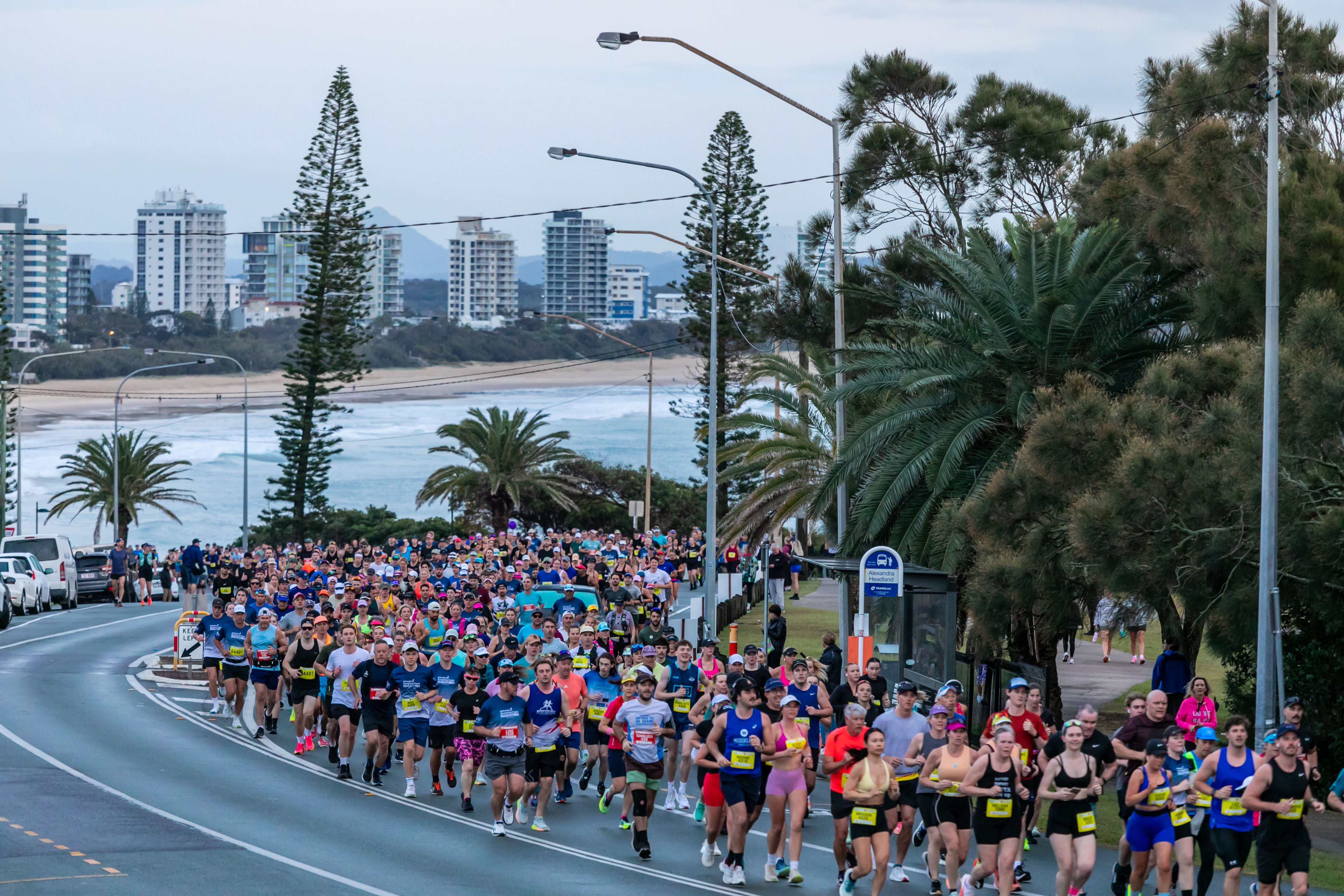 Sunshine Coast Marathon - hundreds of runners on the road, with buildings in the distant background.