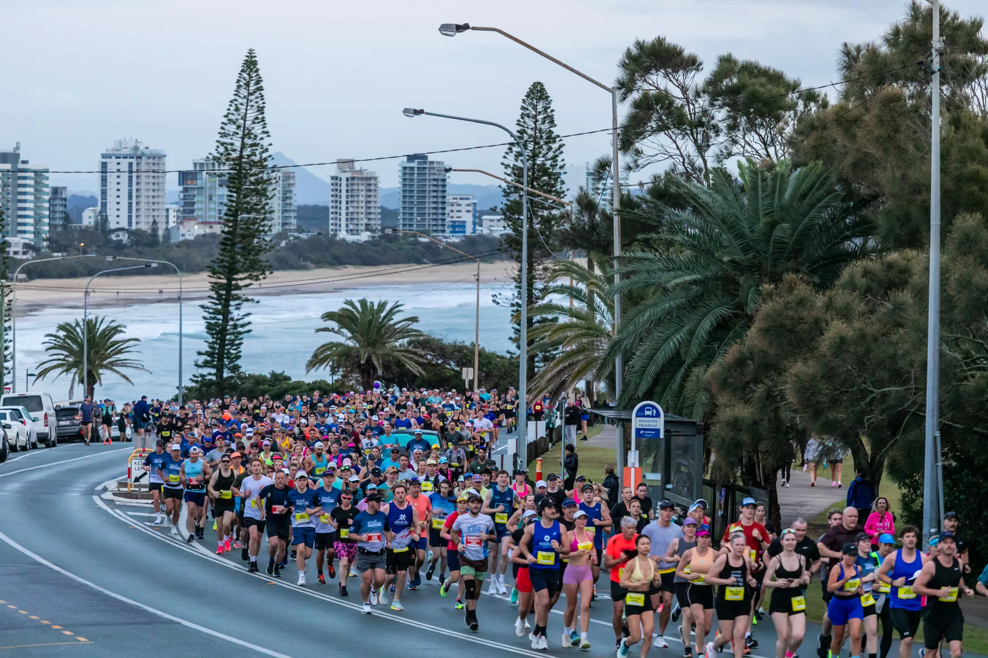 Sunshine Coast Marathon - hundreds of runners on the road, with buildings in the distant background.