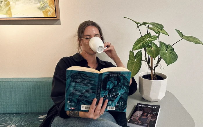 Women reading a book with a cup of tea.