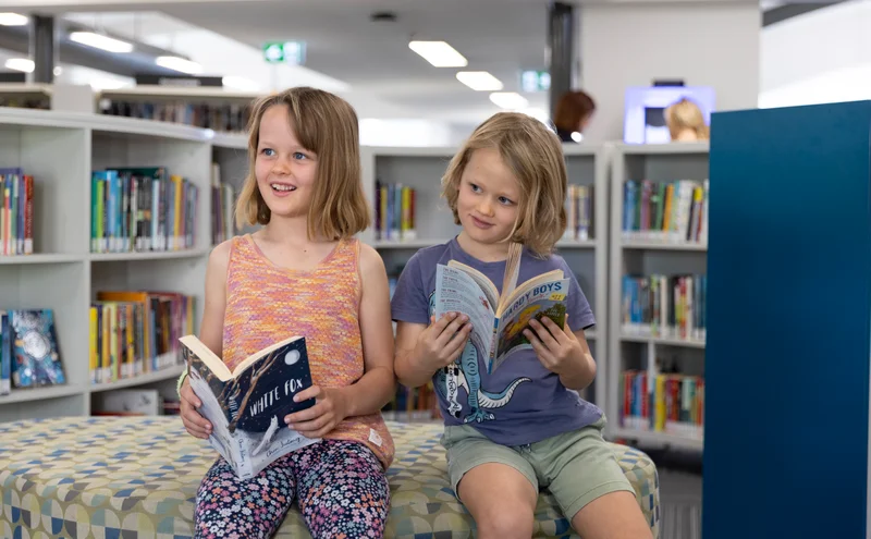 Children reading books in the library.