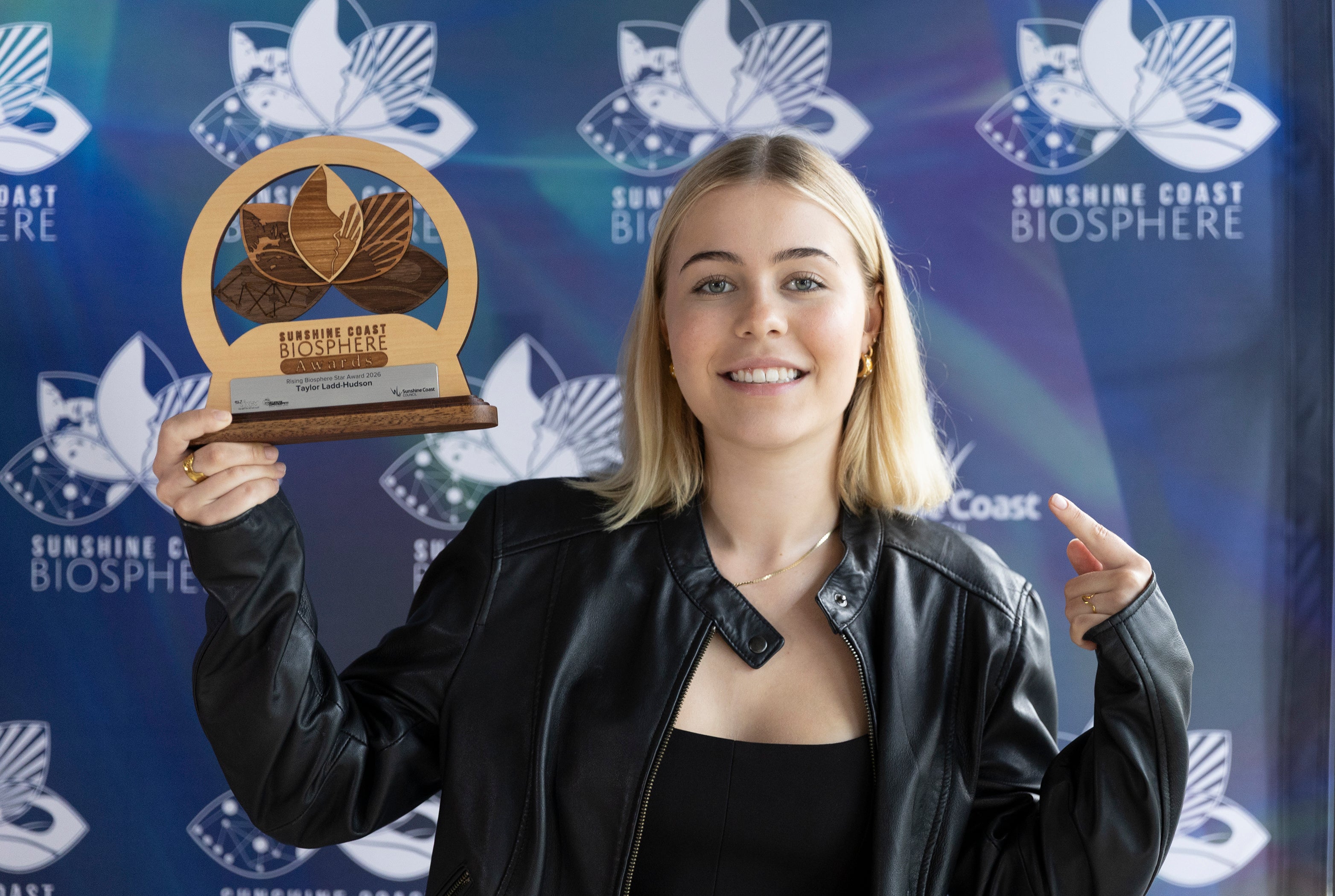 Taylor Ladd-Hudson holds up her Rising Biosphere Star award.