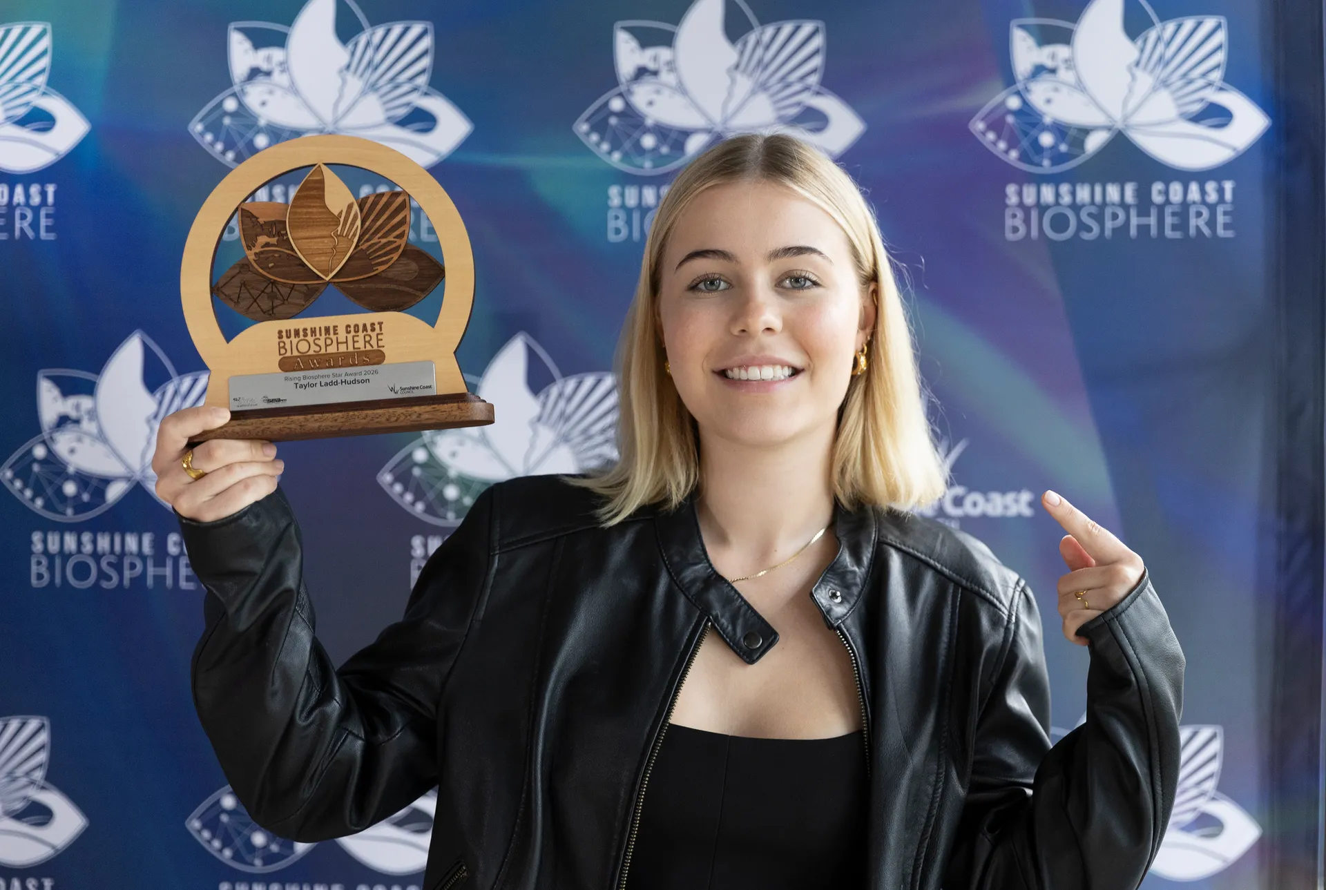 Taylor Ladd-Hudson holds up her Rising Biosphere Star award.